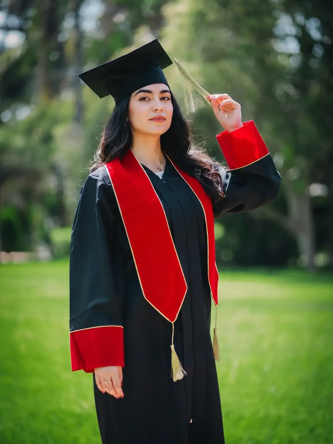 Toge de graduation avec écharpe et parements rouge, portée avec le mortier assorti